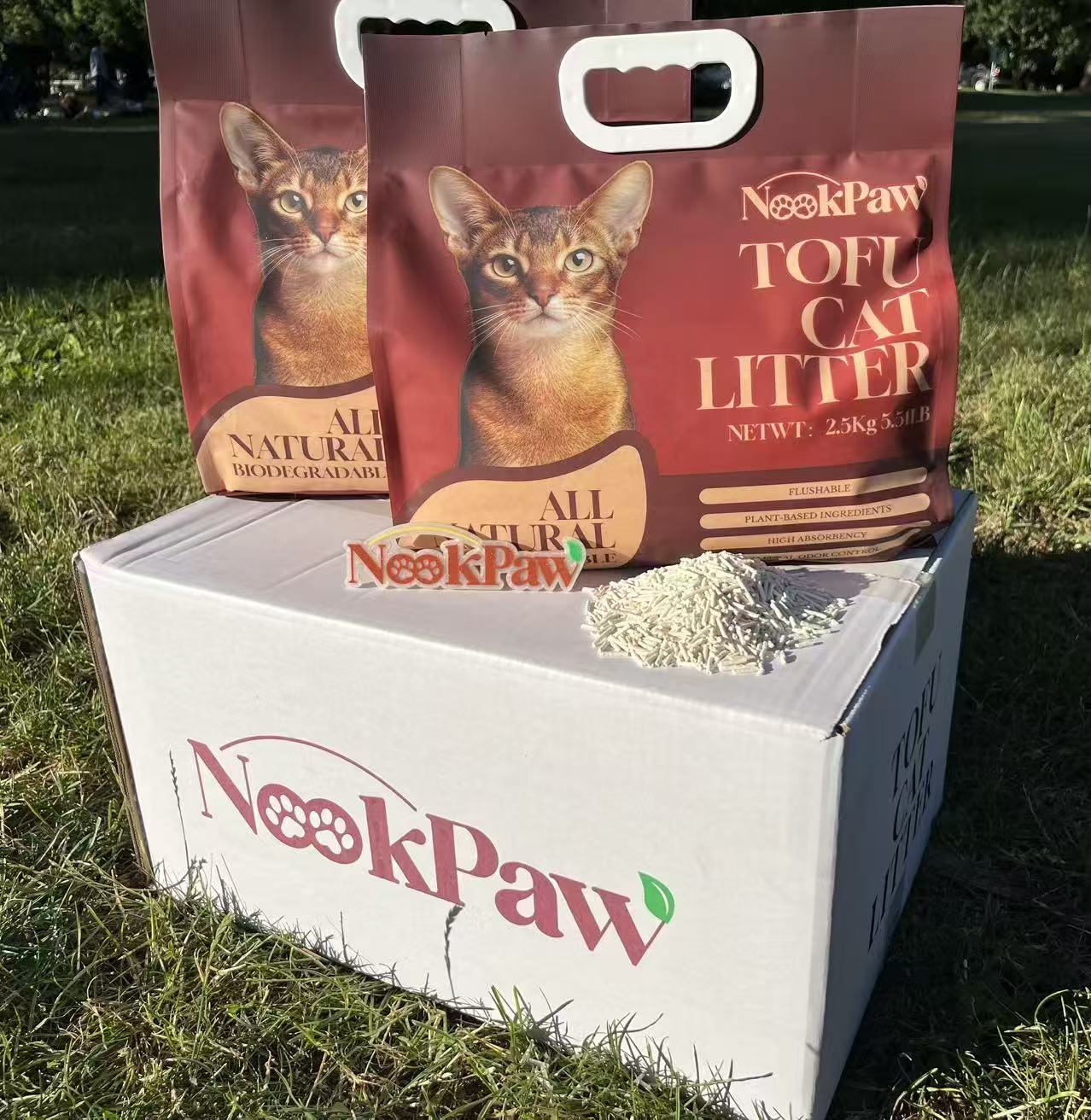 Two NookPaw Tofu Cat Litter bags displayed outdoors with natural tofu pellets