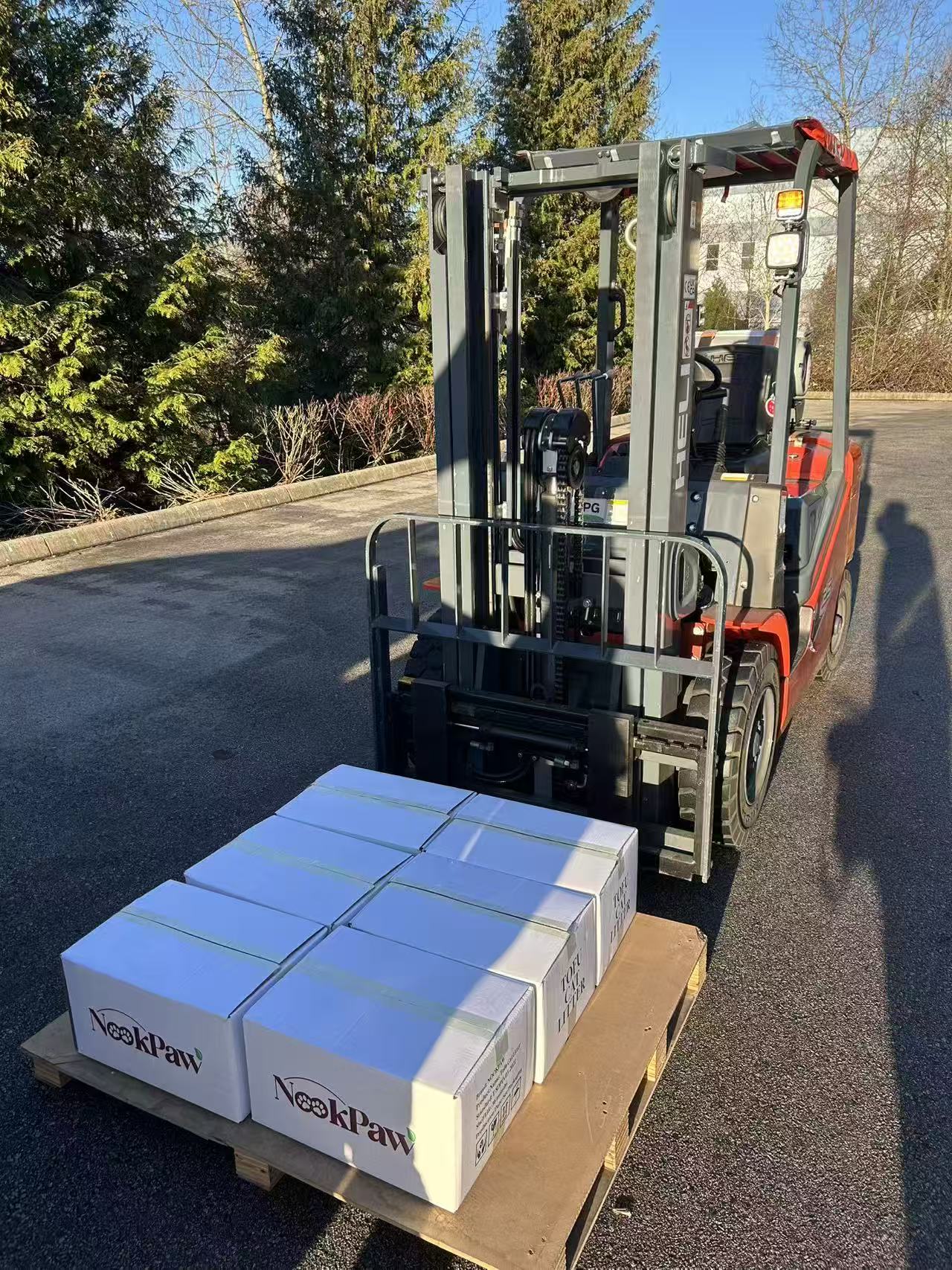 Forklift lifting a pallet of NookPaw boxes after customs pickup